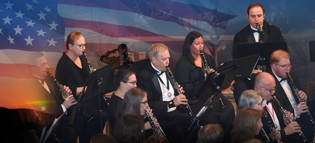 Members of the Orlando Concert Band clarinet section performing on stage, overlaid with a transparent image of the American flag.