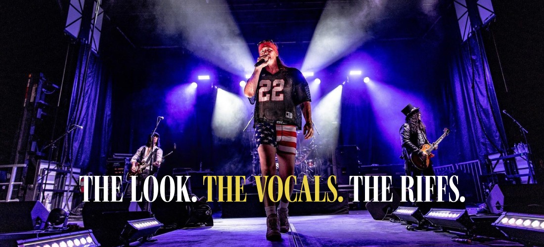 The lead singer of a Guns N' Roses tribute band walks down the center of a purple-lit stage wearing an American flag swimsuit and a jersey numbered 22. Text overlays the bottom reading: "The Look. The Vocals. The Riffs.